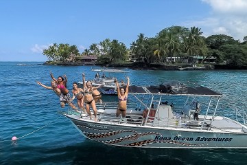 Group Of People Jumping Off A Boat Into The Water