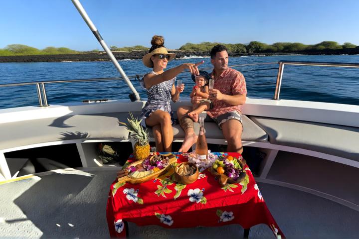 Family on boat having picnic with drinks under sunny sky.