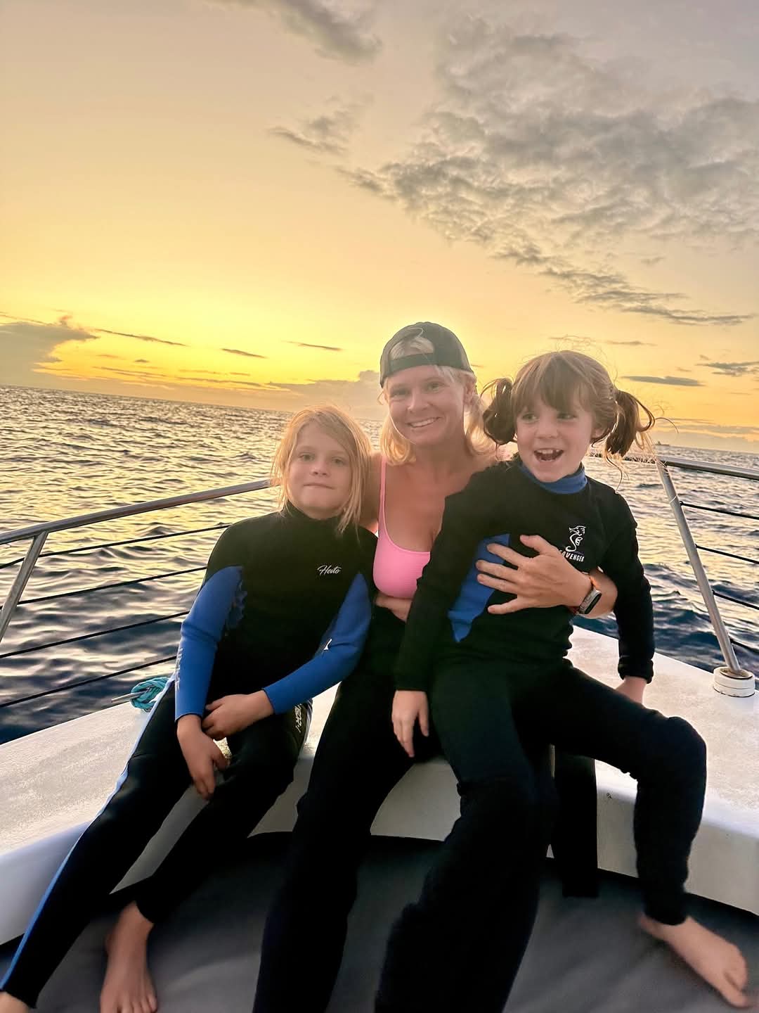 A pair of two young snorkelers and their guardian on our snorkeling charter tour at sunset.