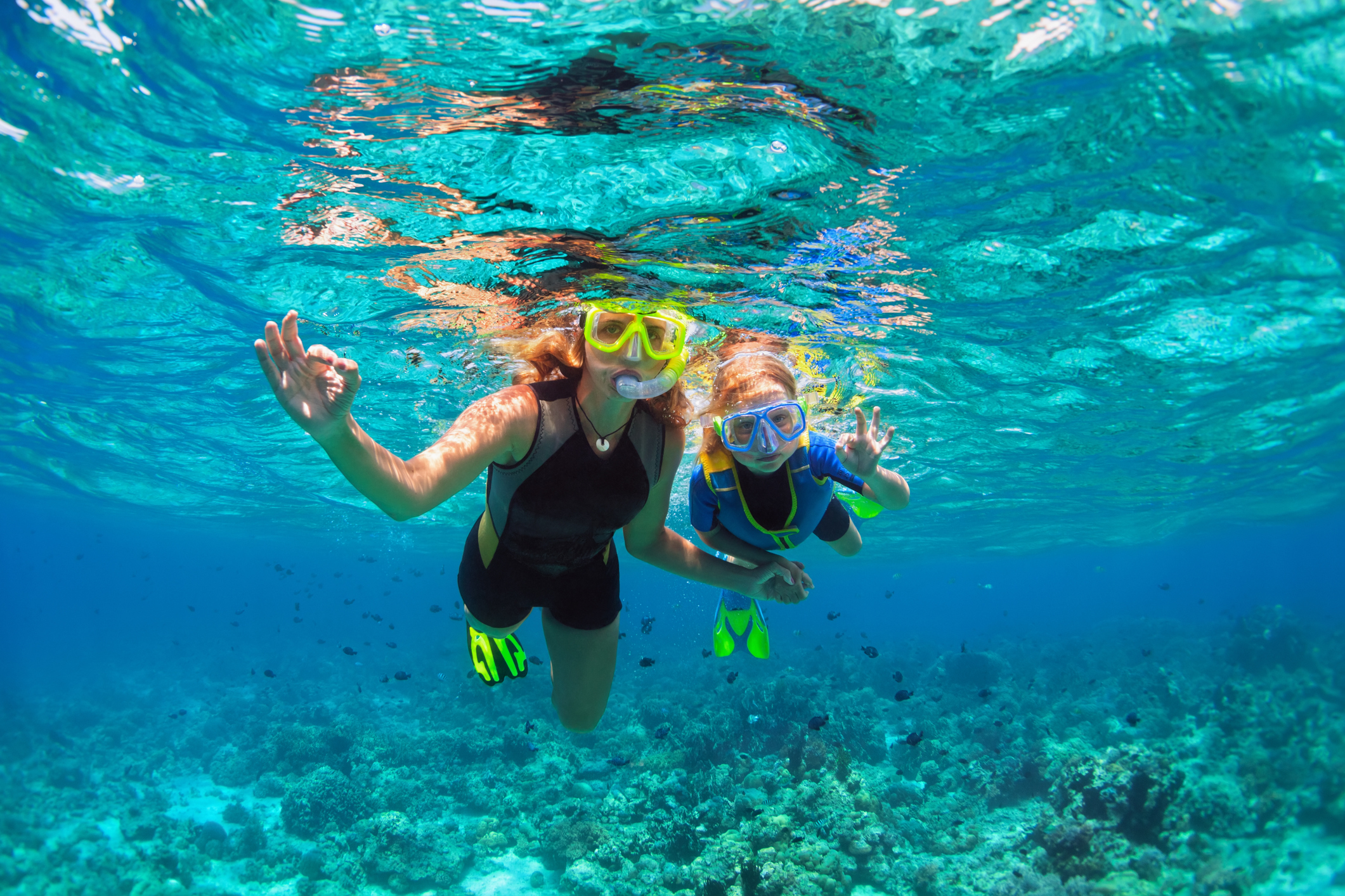 A mother and child enjoy guided snorkeling under the water in Kona, HI.